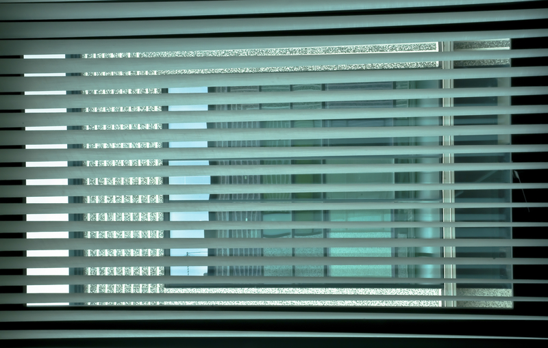 venetian blinds at the office window create an interesting game of colours and colours by drawing a grid on the coloured windows of the building opposite